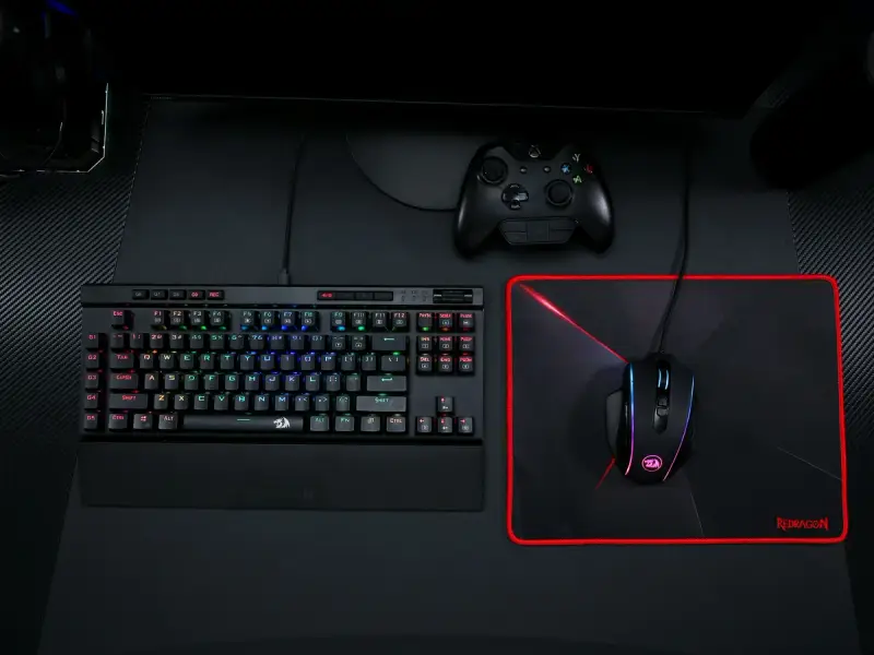 Teclado mecánico, mouse, mousepad y joystick sobre un escritorio
